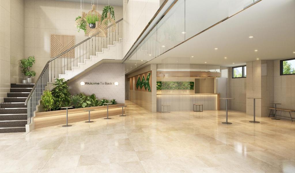 a lobby with stairs and plants in a building at Hotel Il Fiore Kasai Annex in Tokyo
