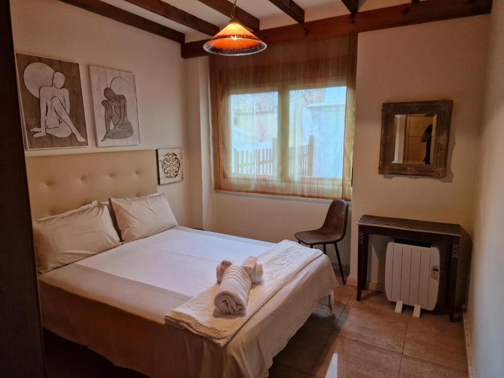 una camera con un letto e una sedia e una finestra di Airam Home Patio Centro ad Almansa