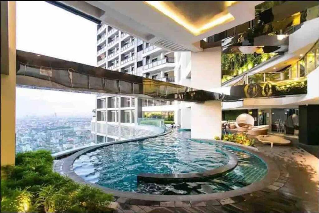 a large swimming pool in the middle of a building at Gramercy Residences 1 Bedroom with balcony facing Garden Lower Floor in Manila