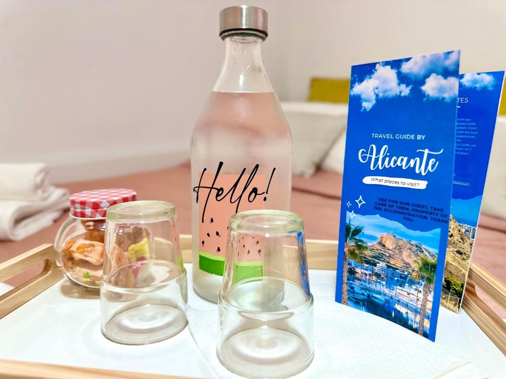 a bottle of water and two glasses on a tray at Moderna habitación en el corazón de Alicante in Alicante