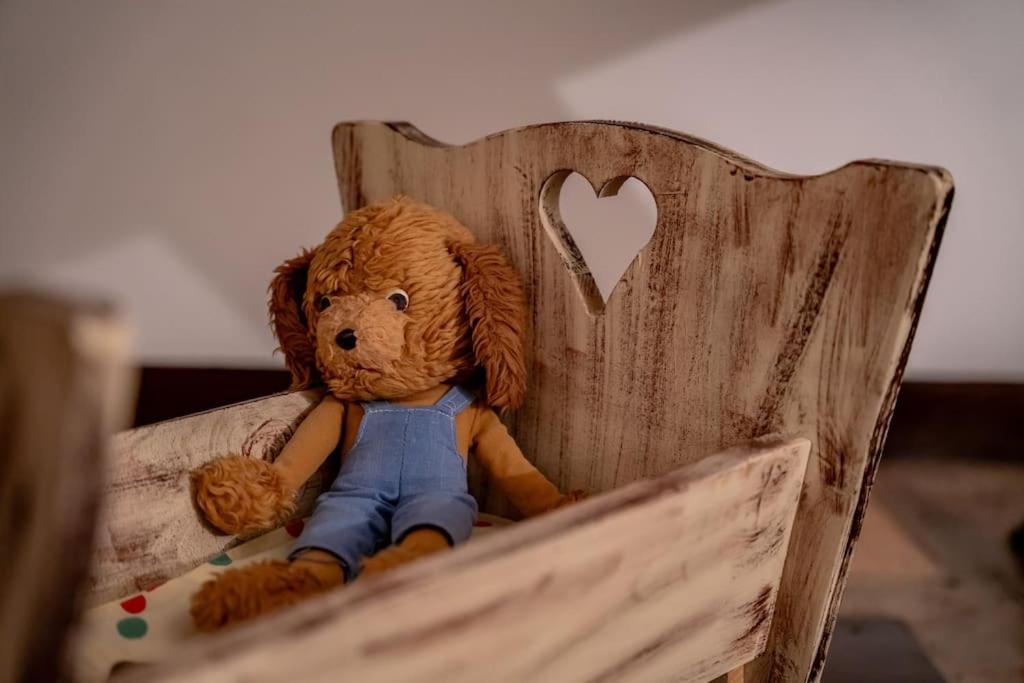 ein ausgestopfter Teddybär auf einem Holzstuhl in der Unterkunft Kuća za odmor Treasure Hunters Academy in Bjelovar