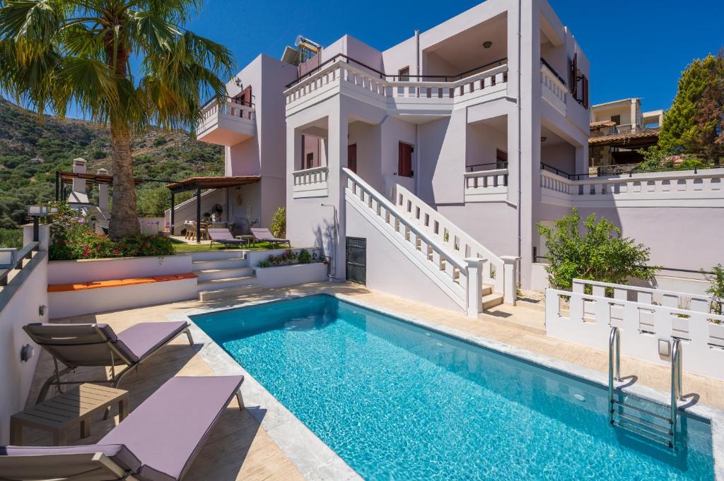 a villa with a swimming pool and a house at Sounds Of The Mountain Chania in Varípetron