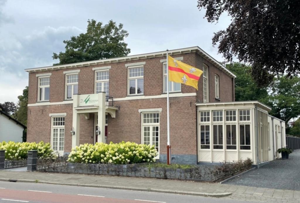 un edificio con una bandera delante de él en De 4 seizoenen, en Loenen