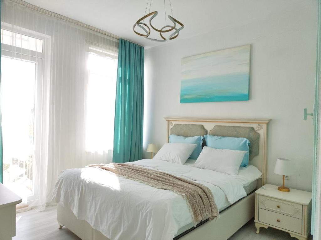 1 dormitorio con 1 cama grande y cortinas azules en Central flat close to the sea fast Wi-Fi, en Antalya