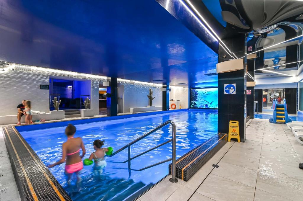 dos niños en una piscina en un hotel en Hotel SPA Faltom Gdynia Rumia, en Rumia