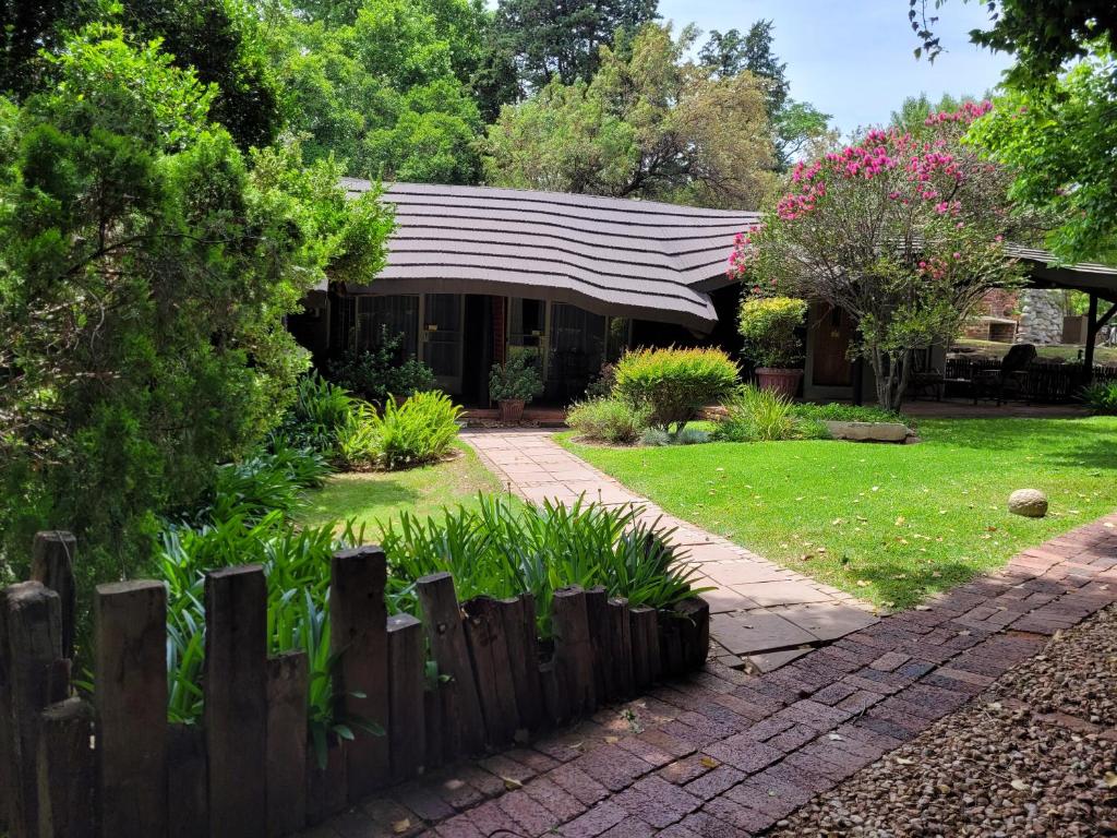 a house with a wooden fence in a yard at Riverbush Lodge Guesthouse in Parys