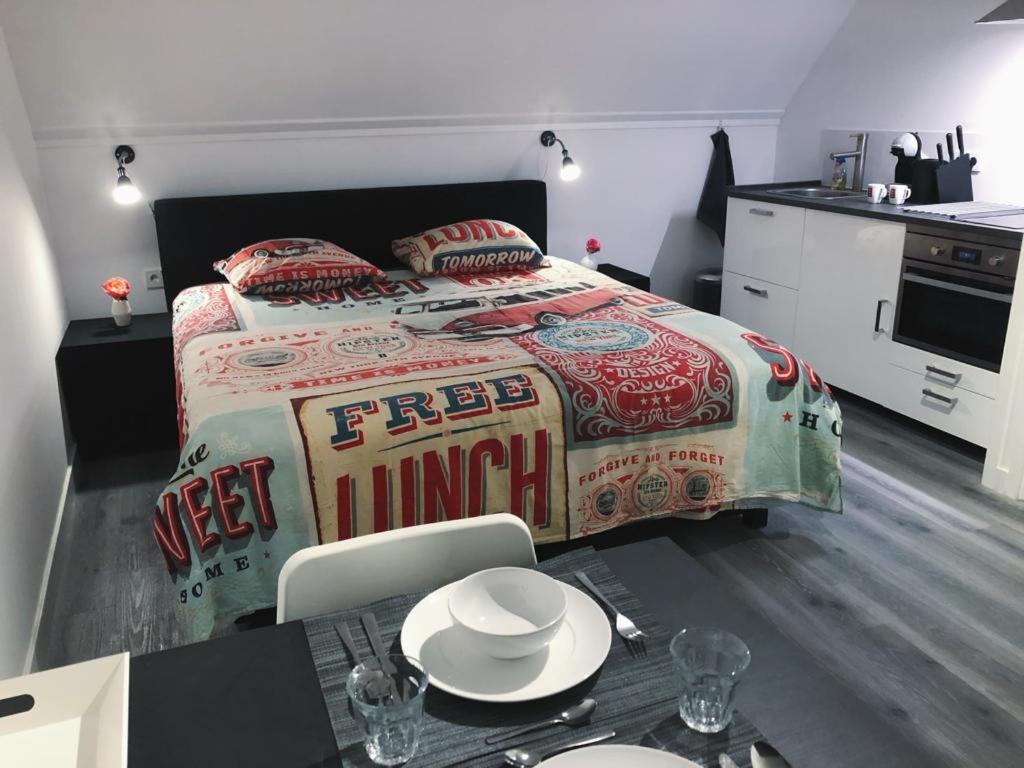 a bedroom with a bed and a table with plates on it at All-in Penthouseroom in Amsterdam