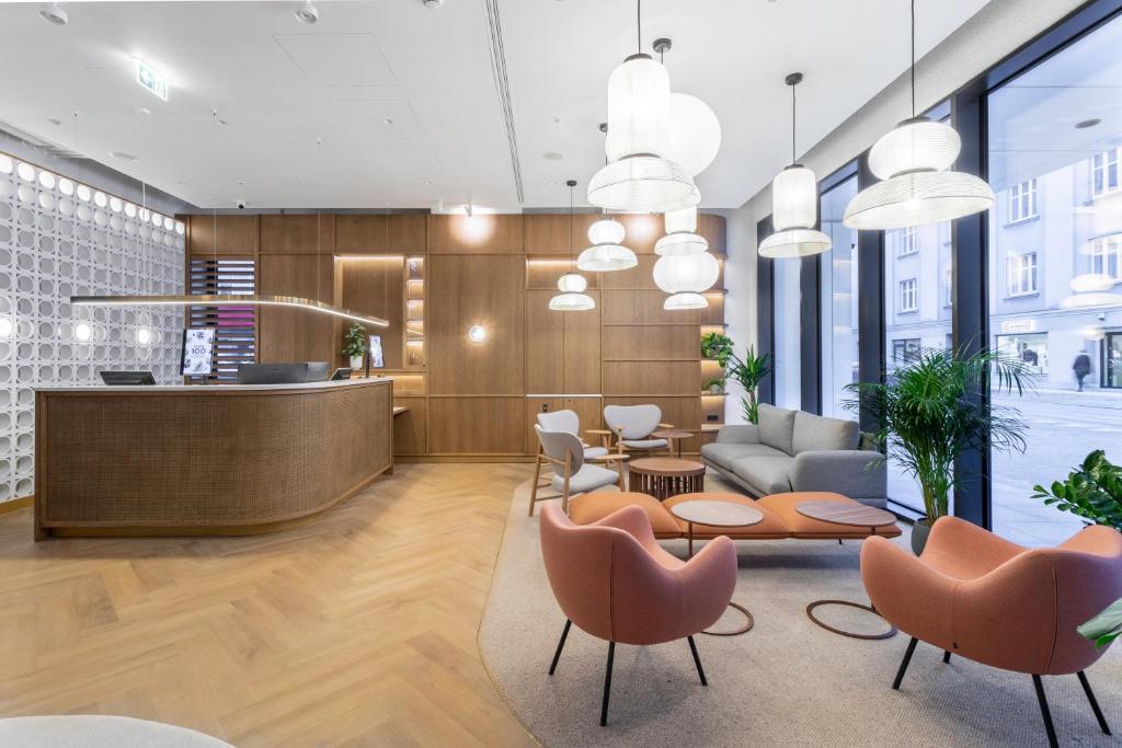 a lobby with a waiting area with chairs and a table at Qubus Hotel Katowice in Katowice