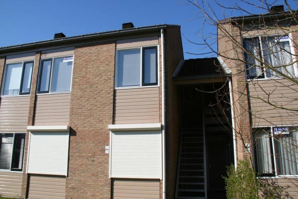 Una casa de ladrillo con puertas blancas de garaje. en Schorrebloem 21*, en Nieuwvliet