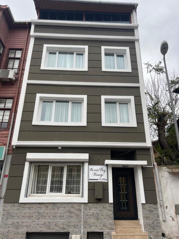 une maison marron et blanche avec un panneau sur elle dans l'établissement DERVİŞ BEY KONAĞI, à Istanbul