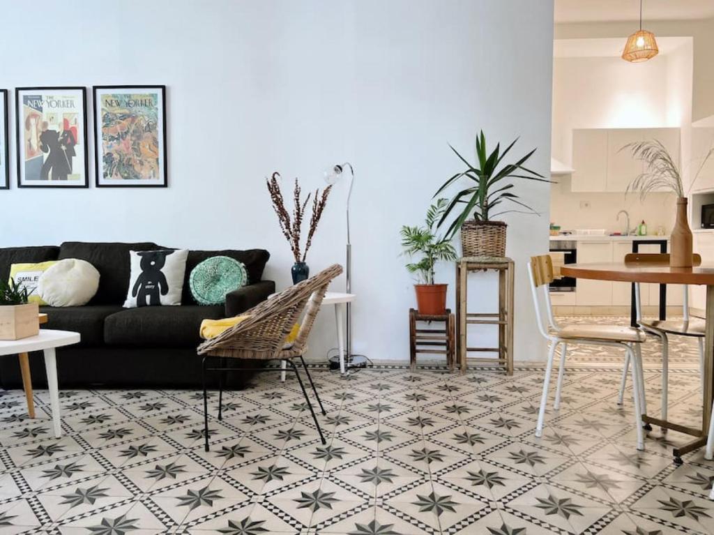 a living room with a black couch and a table at Vintage Apt 4BR Mar Mikhael in Beirut