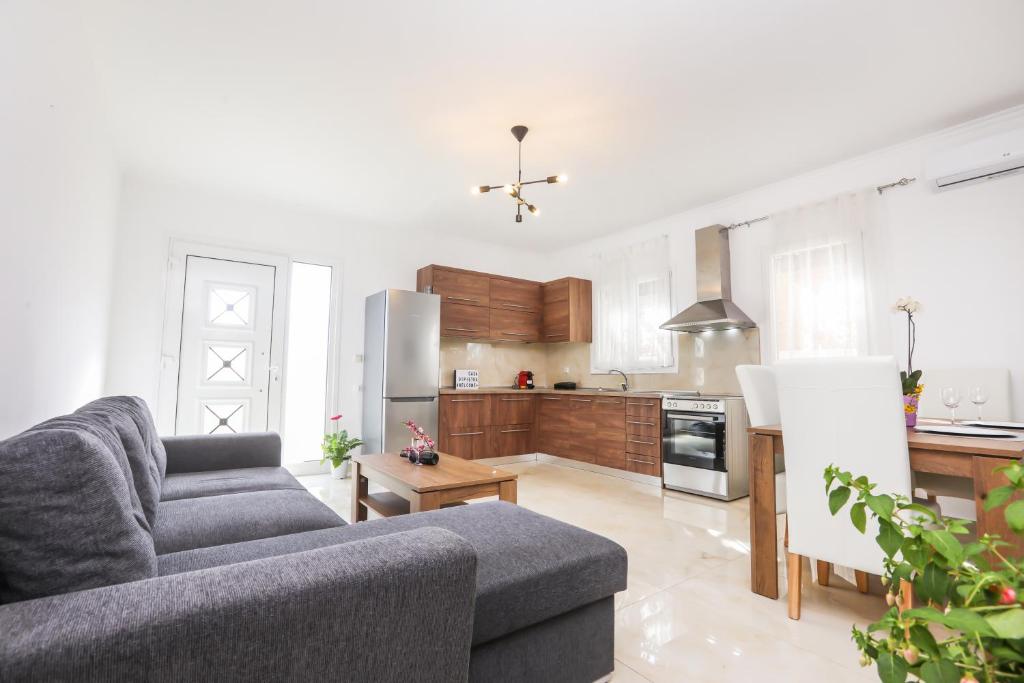 a living room with a couch and a kitchen at Contessa Caterina in Karousádes