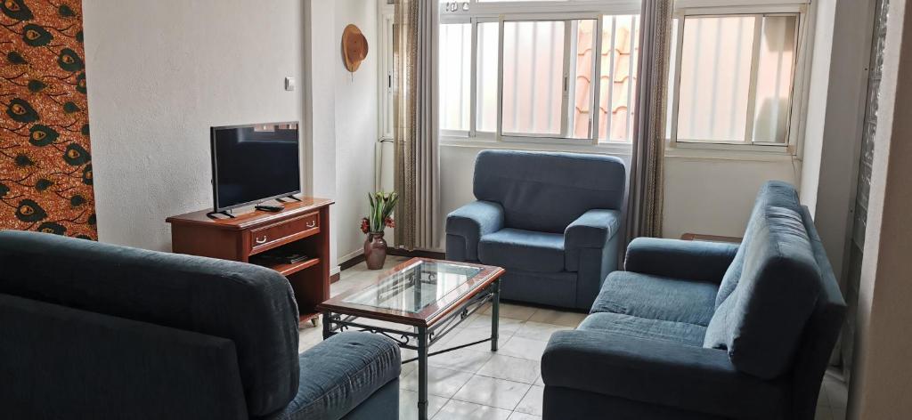 sala de estar con 2 sillas azules y TV en Plateau Paradise, en Praia