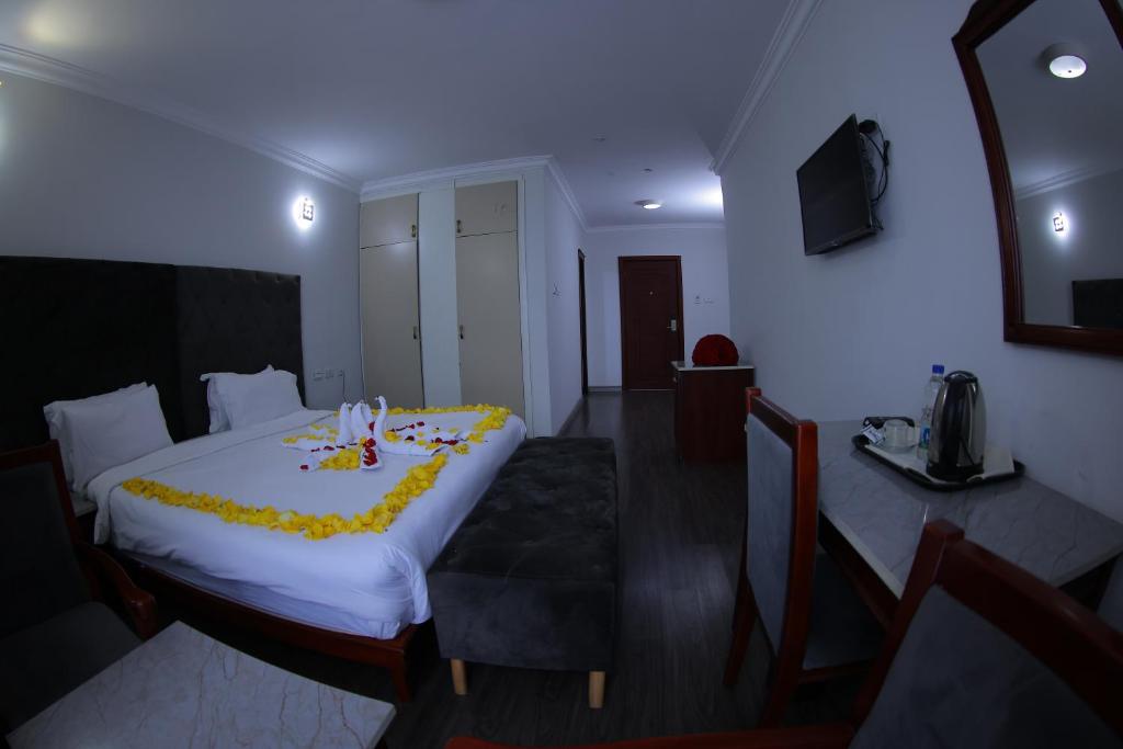 una camera d'albergo con un letto e un tavolo con fiori di Trinity Hotel ad Addis Abeba