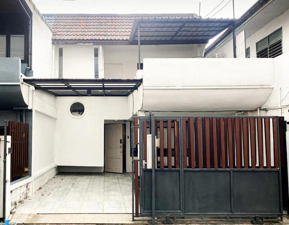 une maison blanche avec une porte en face dans l'établissement 3BR entire house next to Skytrain(BTS) and Subway(MRT) Chatuchak, à Bang O