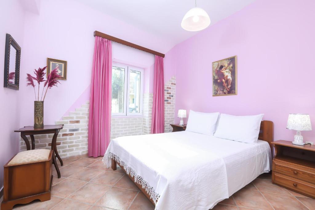 sypialnia z białym łóżkiem i różowymi zasłonami w obiekcie Coryfo Casetta, Mon Repo w Korfu