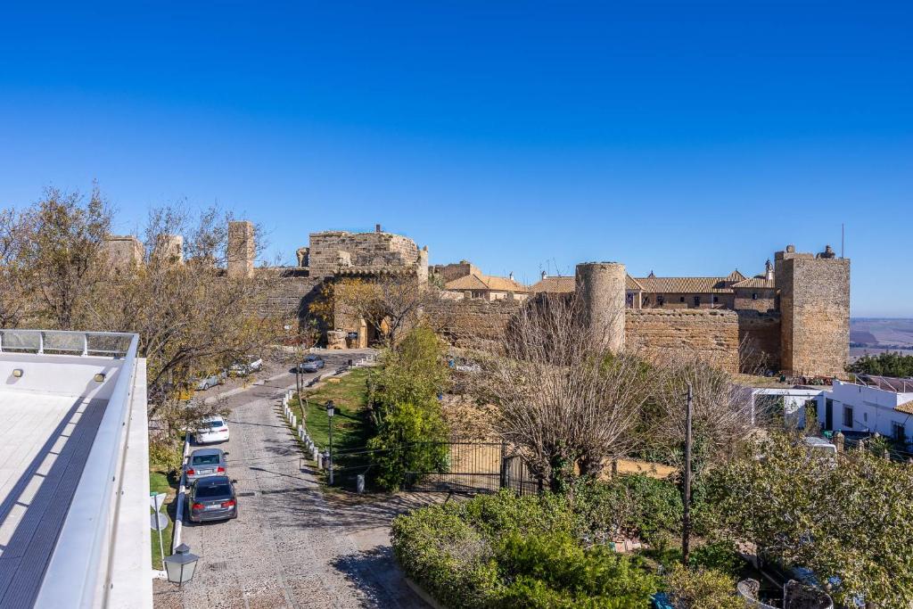 a view of a castle with cars parked on a street at Casa Xanadu Carmona - Stylish villa with rooftop terrace and stunning views of Parador in Carmona