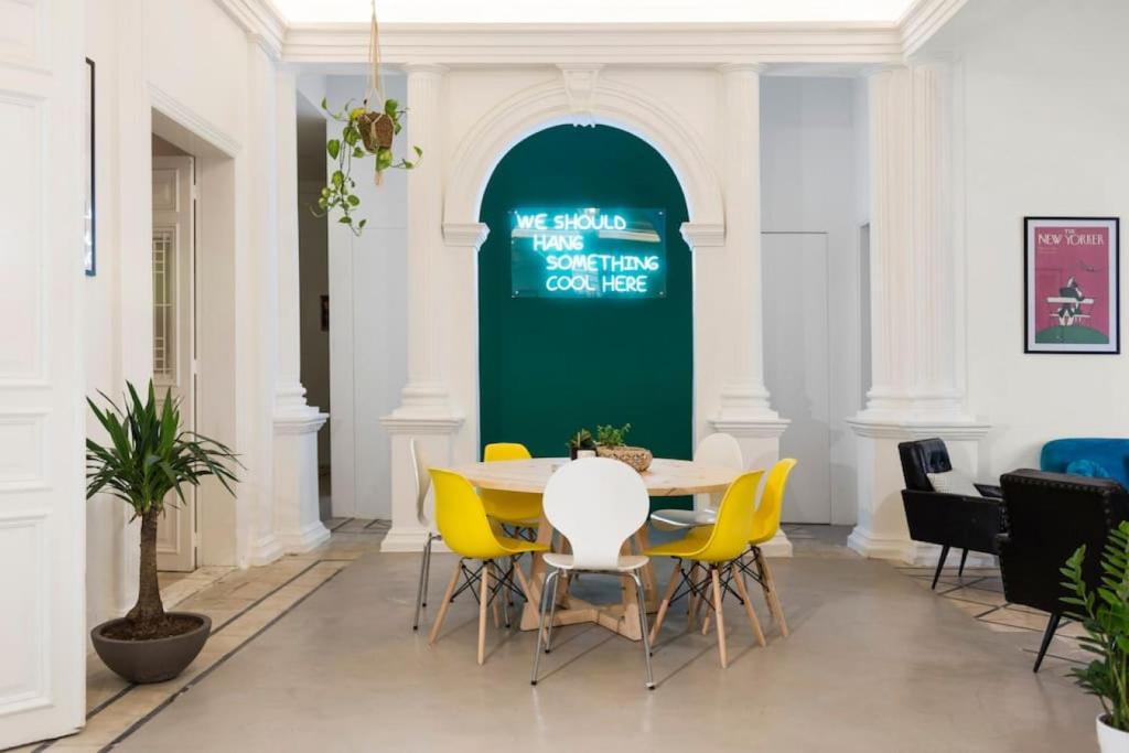 a dining room with a table and yellow chairs at Little Urban Palace 4BR Beirut in Beirut