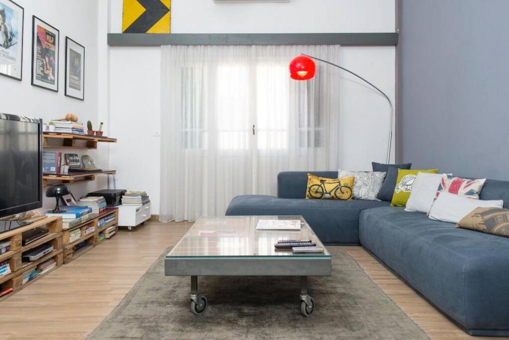 a living room with a blue couch and a coffee table at Bright Architect Home in Badawi With Rooftop in Beirut