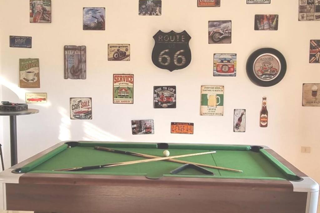 a green pool table in front of a wall with a clock at 3 Bedroom mountain view apartment overlooking Al Fuhais in Amman