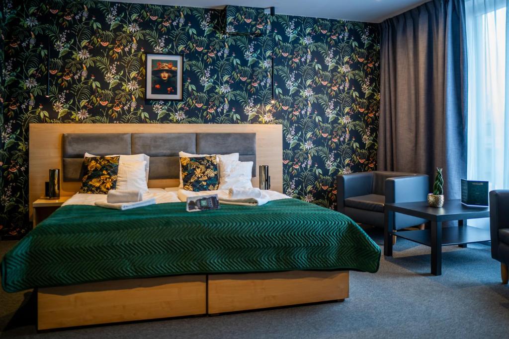 una camera con letto e piumone verde di Seven Hotel Bytom - Katowice a Bytom