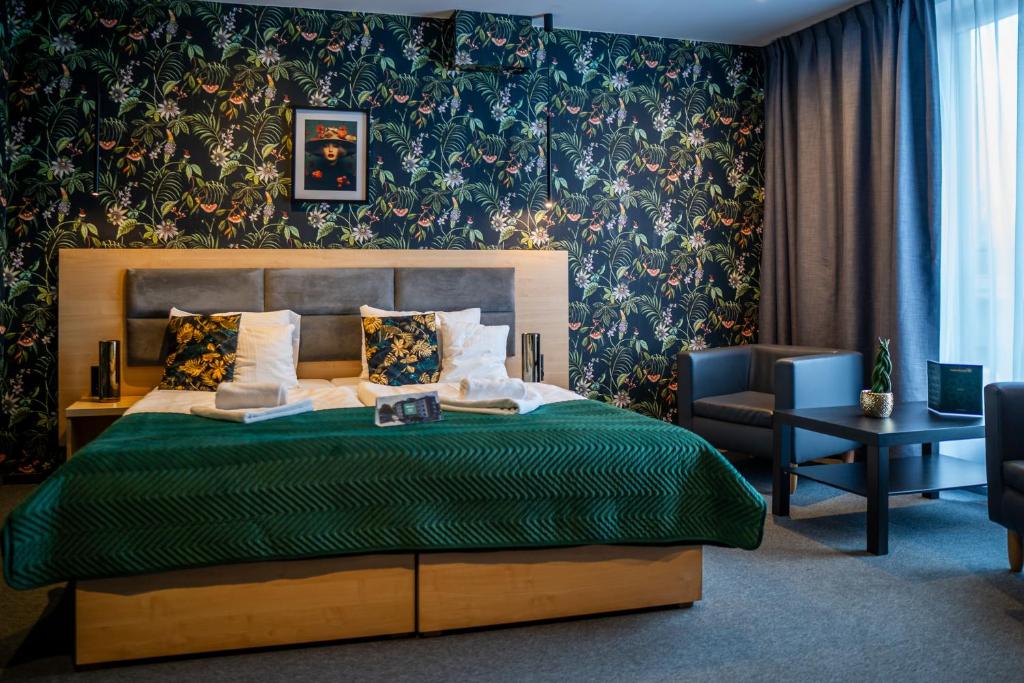a bedroom with a bed with a green comforter at Seven Hotel Bytom - Katowice in Bytom