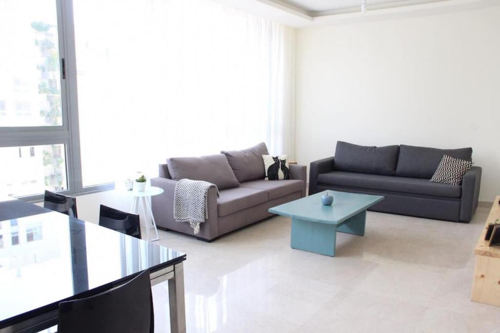 a living room with two couches and a table at Modern 3BR Apt next to Hotel Dieu in Beirut