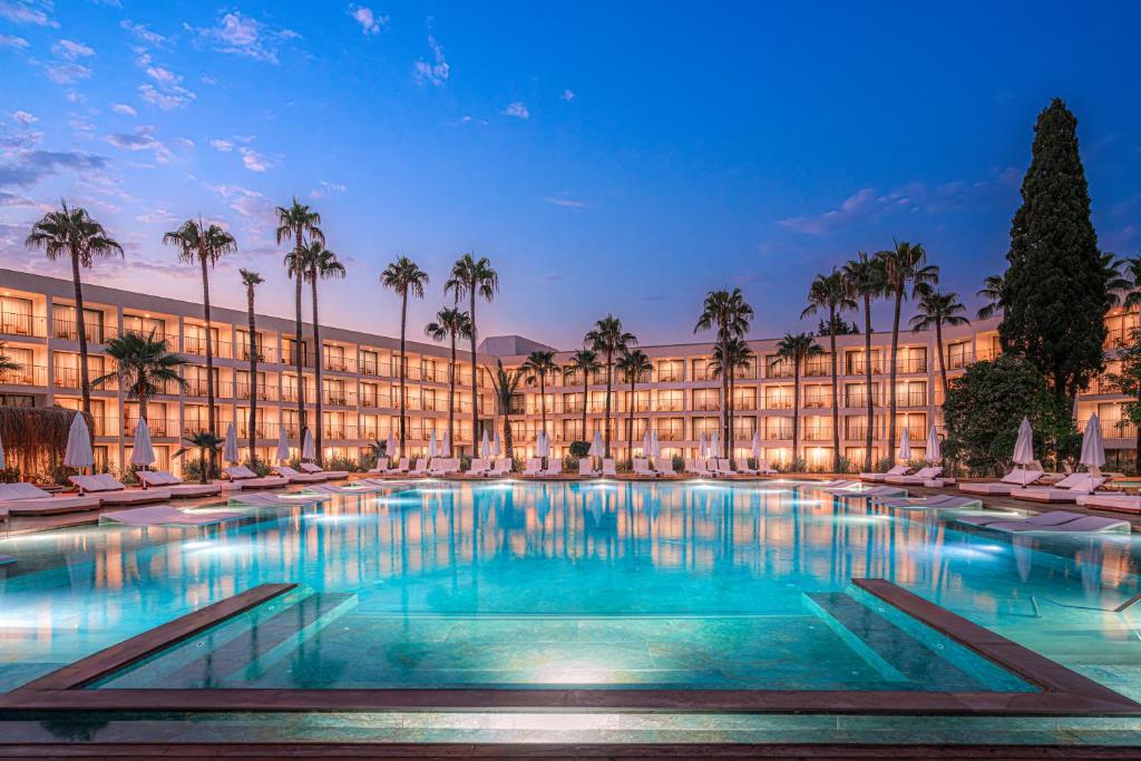 a large pool in front of a building with palm trees at Yalihan Aspendos in Alanya