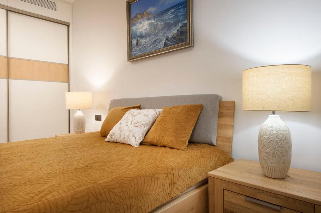 a bedroom with a bed with a lamp on it at Apartament Premium PINEA 203 in Pobierowo