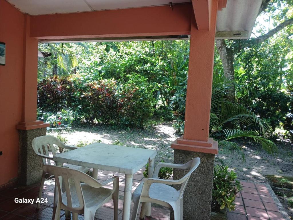 una mesa y sillas sentadas en un porche en Hospedaje Eden, en Los Naranjos