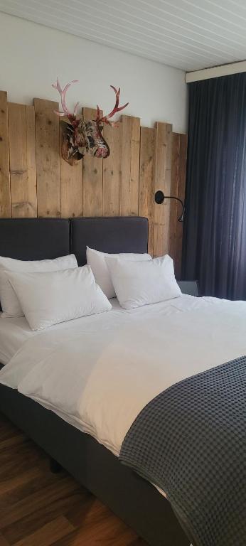 1 cama grande con sábanas y almohadas blancas en Kreuzblume Hotel & Weinstube en Friburgo de Brisgovia