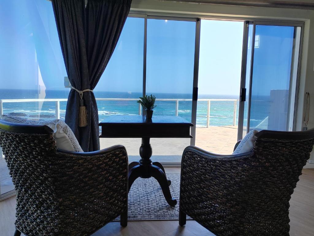 a table and chairs with a view of the ocean at Casa Seaviews in Port Elizabeth