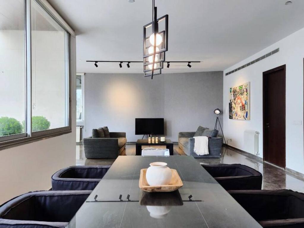 a living room with a large table and chairs at Chic Contemporary 3BR in Mar Mikhael in Beirut