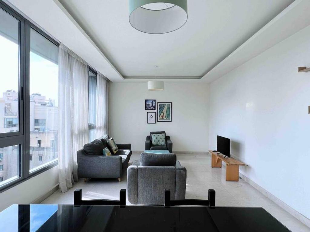 ein Wohnzimmer mit 2 Sofas und einem TV in der Unterkunft Modern 3BR Apt next to Hotel Dieu in Beirut