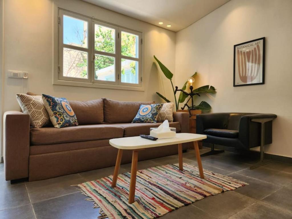 a living room with a brown couch and a table at Railway House 2BR Apt w front yard in Beirut