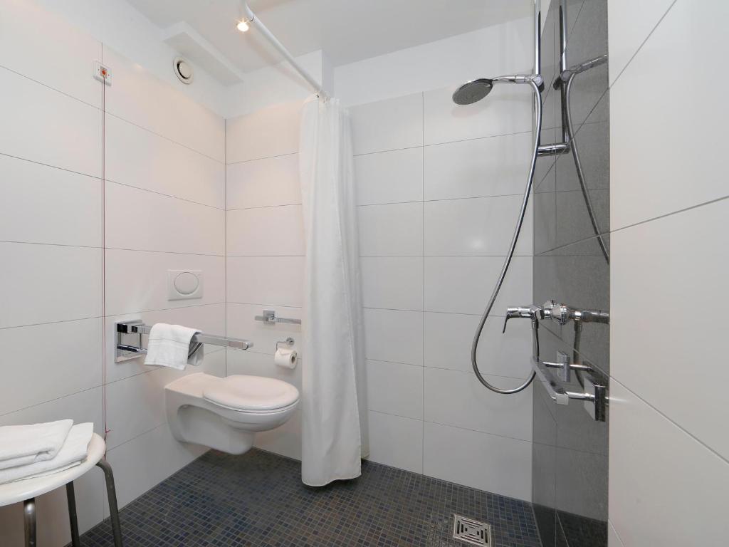 a bathroom with a toilet and a shower at B&B Hotel Berlin-Dreilinden in Kleinmachnow