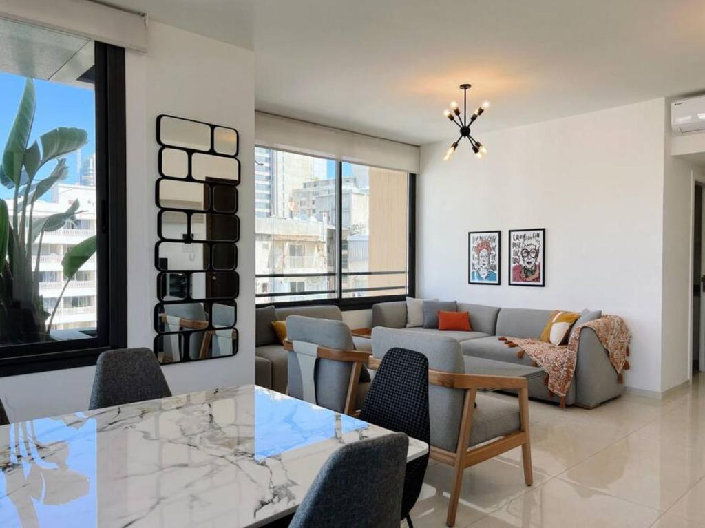 ein Wohnzimmer mit einem Sofa und einem Tisch in der Unterkunft Elevated 2BR living in Hamra in Beirut
