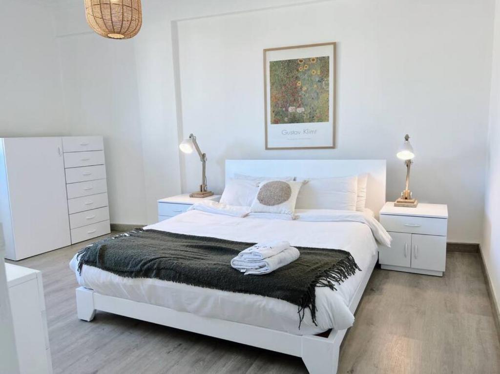 ein weißes Schlafzimmer mit einem großen Bett und zwei Nachttischen in der Unterkunft Chill 2Br haven Gemmayze in Beirut