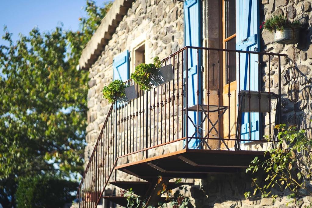 einen Balkon in einem Gebäude mit Topfpflanzen darauf in der Unterkunft Domaine Insolite du Petit Moras in Chomérac