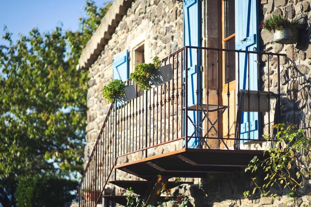 a balcony on a building with potted plants on it at Domaine Insolite du Petit Moras in Chomérac