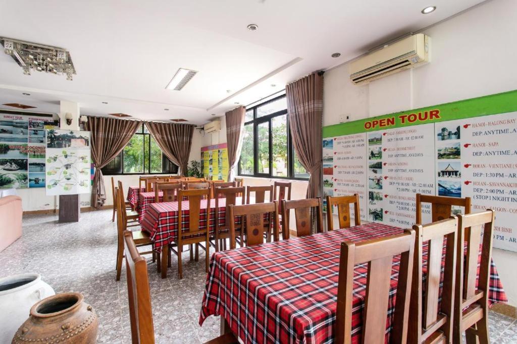 un restaurante con mesas y sillas y un cartel en la pared en Cua dai beach hotel overview beach & river en An LÆ°Æ¡ng (1)