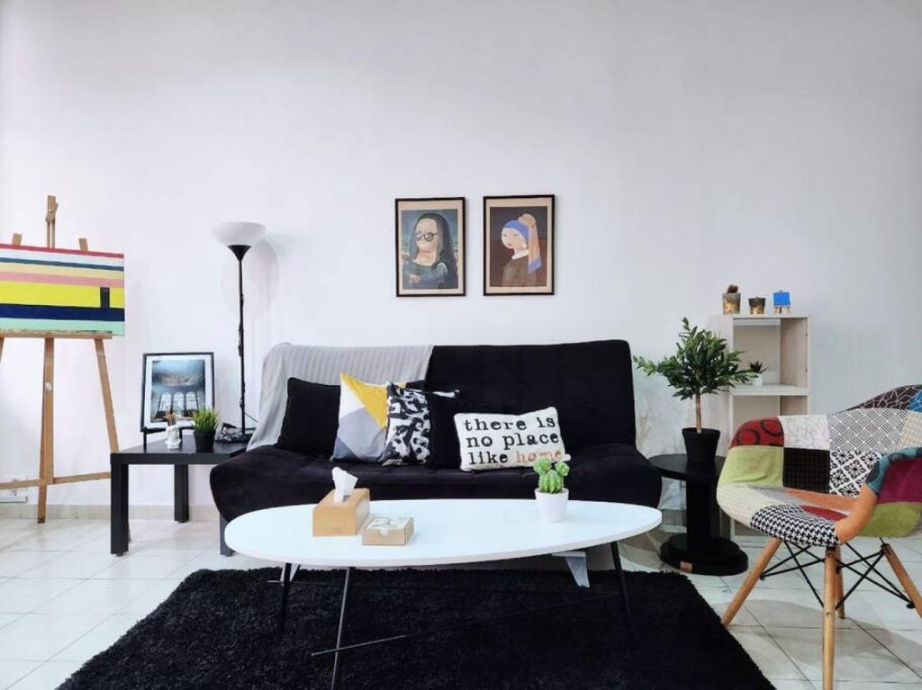 a living room with a black couch and a white table at Artist Nest In Getaoui, Achrafieh in Beirut