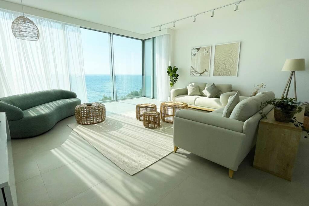 a living room with two couches and a view of the ocean at Amchit Bay Beach Residences 3BR Rooftop w Jacuzzi in Jbeil