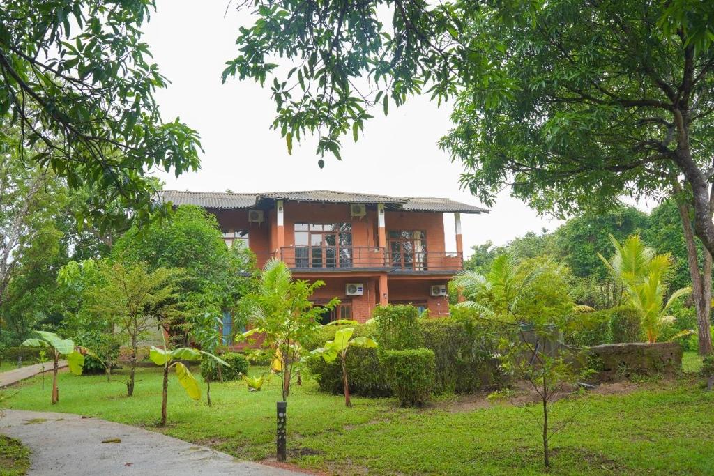 Sigiriya Cottage في سيجيريا: منزل في وسط حديقة فيها اشجار