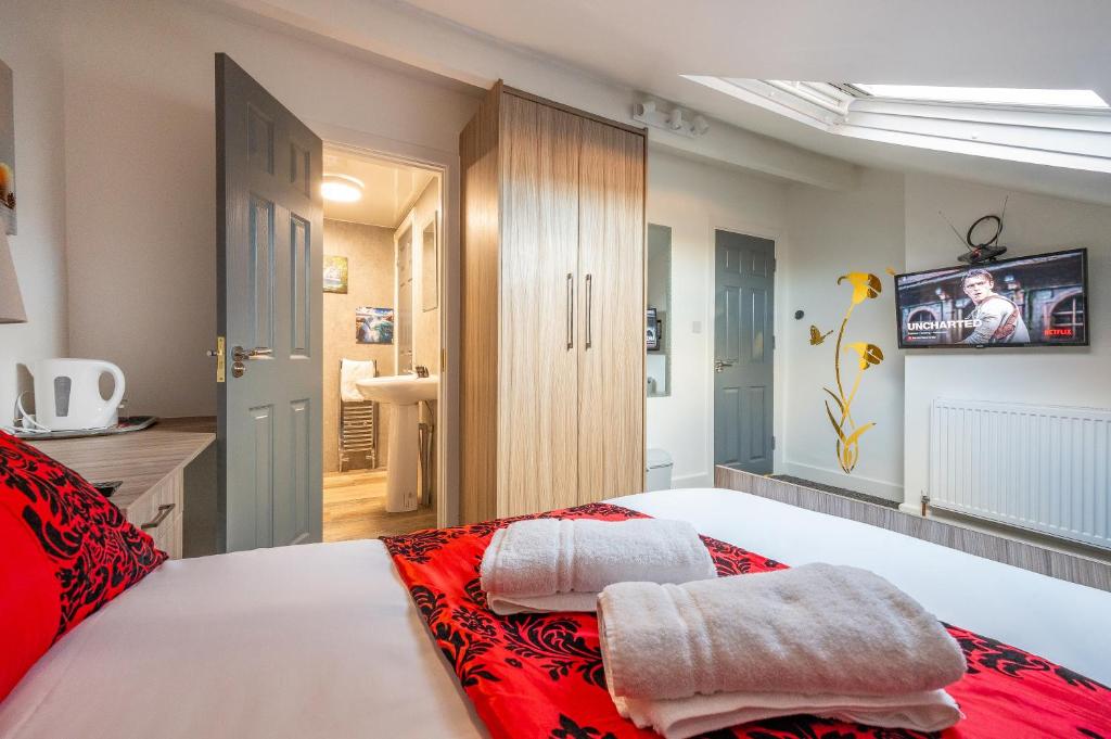 1 dormitorio con 1 cama con 2 toallas en *RA12s* For your most relaxed & Cosy stay + Free Parking + Free Fast WiFi *, en Headingley