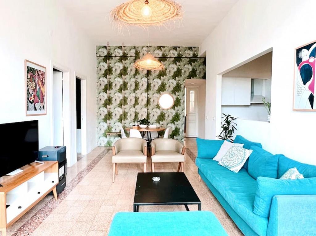uma sala de estar com um sofá azul e uma mesa em Bright Loft 4BR MarMikhael em Beirute