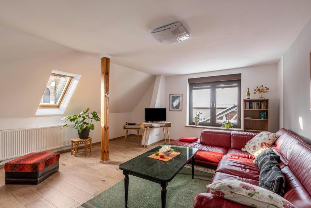 ein Wohnzimmer mit einem roten Sofa und einem Tisch in der Unterkunft Ferienwohnung Am Süßen See in Seeburg