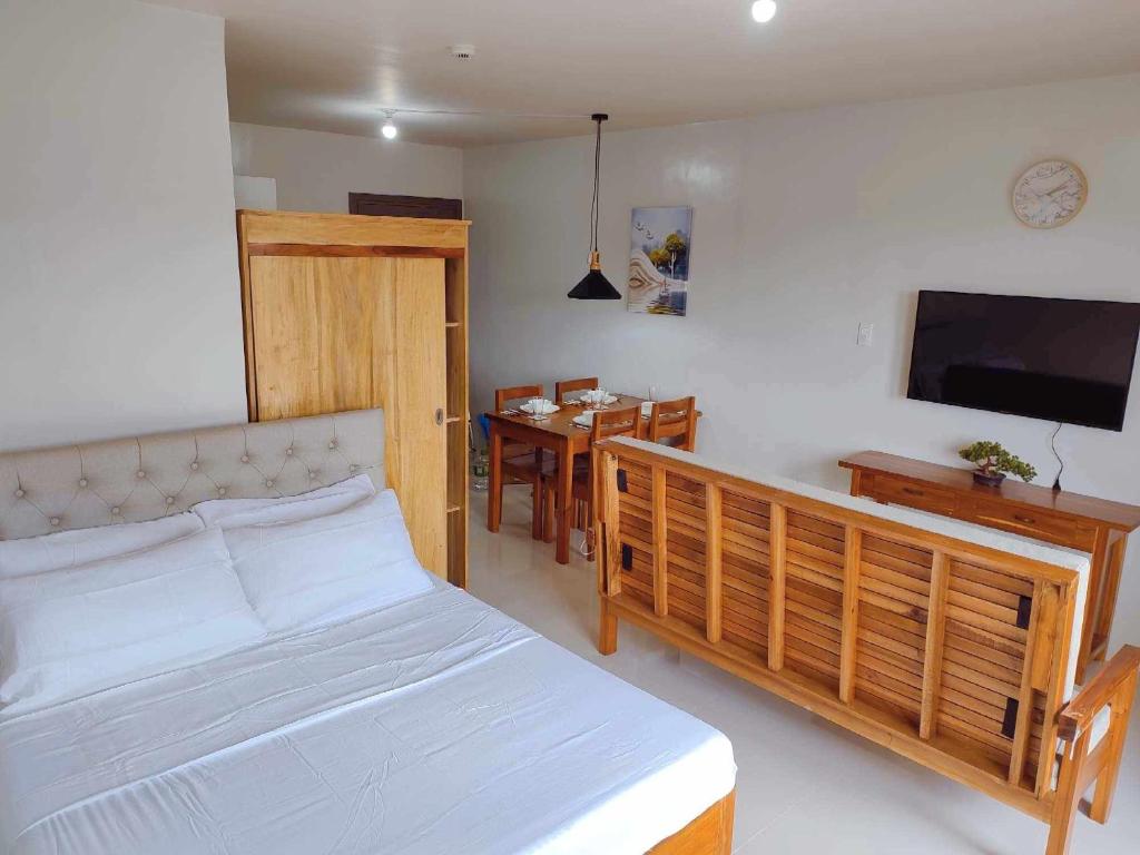 a bedroom with a bed and a dining room at Palawan Paradise Condotel 5H in Puerto Princesa City