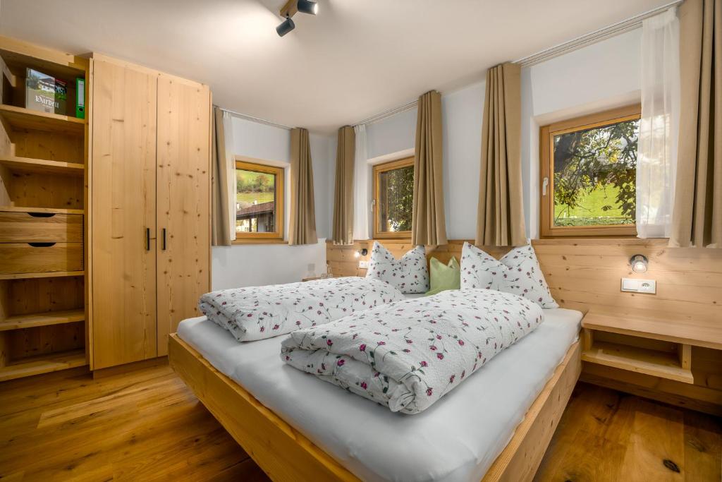 Un dormitorio con una cama grande con almohadas. en Pardellerhof Lüsen Doppelzimmer Nussbaum, en Luson