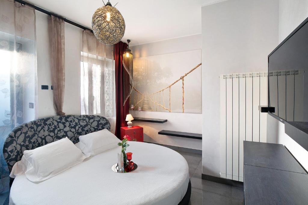 Un dormitorio con una cama blanca y una silla. en La dimora della Poesia, en Imperia